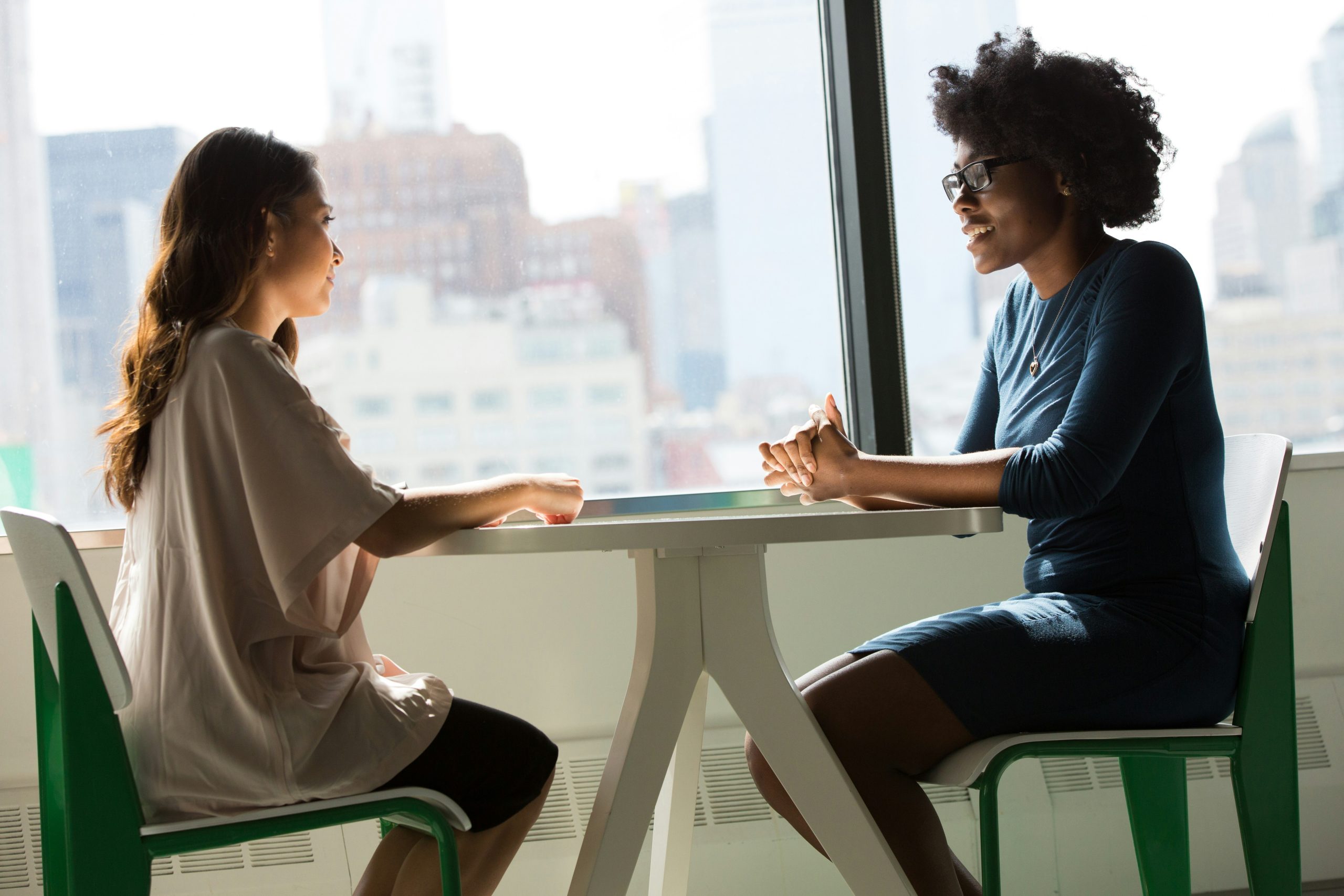 two women speaking at a table